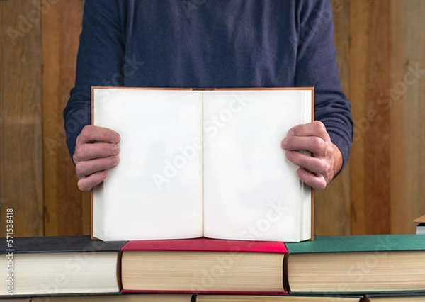 Fototapeta man holding a book showing its blank pages