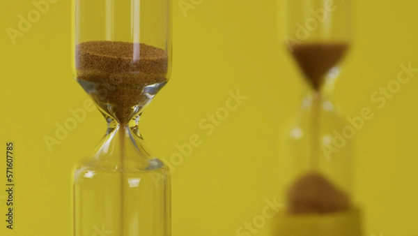 Obraz Hourglasses On A Yellow Background