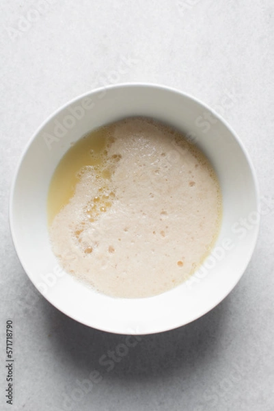 Fototapeta Activated yeast with water and melted butter, dry yeast granules on water, foamy yeast