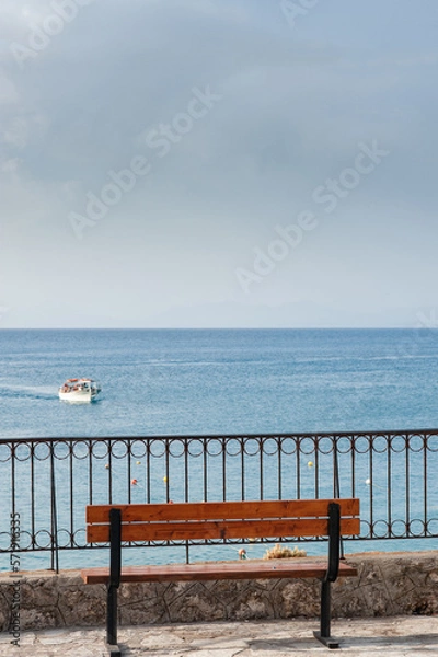 Fototapeta An empty bench with a view at the sea

