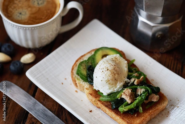 Fototapeta homemade healthy open sandwich: toast topped with spinach, tuna, avocado and poached egg