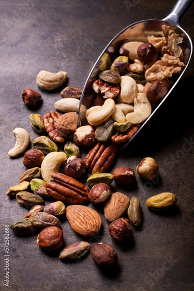 Fototapeta in the foreground, a food scoop with an assortment of shelled nuts