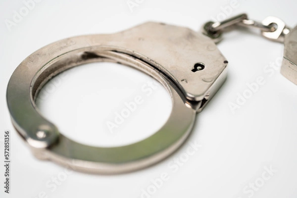 Obraz Object is a unilateral handcuff made of iron, single lock, on a white background, symbolizing the law and the offense.