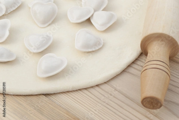 Fototapeta Dumplings in a heart shape dough and rolling pin.