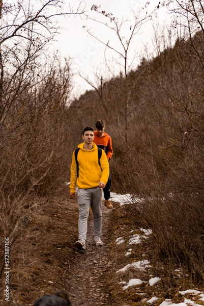 Fototapeta Walking and smiling while having a fun time together in the forest