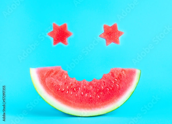 Fototapeta A smile of watermelon on a blue background, star eyes