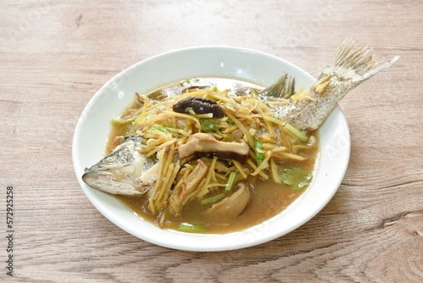 Obraz steamed bass fish dressing soybean gravy sauce topping slice ginger and mushroom on plate 