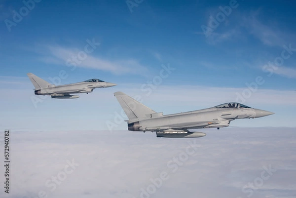 Fototapeta Typhoon Fighter Jet in Flight. Action photograph of Fast Jet military aeroplane on a combat mission air to air above the sea. a pair of fighter jets on a long range combat air patrol