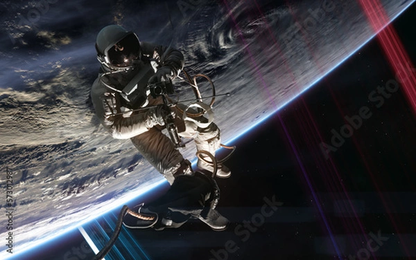 Fototapeta Astronaut in outer space orbiting distant planet. Science fiction. Elements of this image furnished by NASA