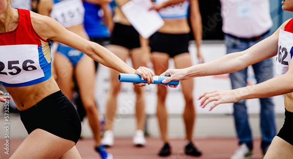 Obraz women relay team passing of baton running 4x400 meters