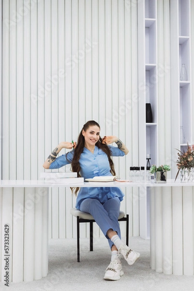 Fototapeta The cosmetic dermatologist's work desk is surrounded by carefully chosen accessories, plants, and books, creating a relaxing and personalized environment for her patients.