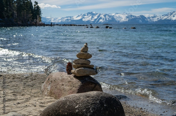 Fototapeta Stack of rocks on the beach of a mountain lake