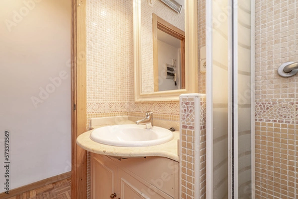 Fototapeta Bathroom with cream marble top and mirror with wooden frame and shower tray with gresite tile and oak door frames