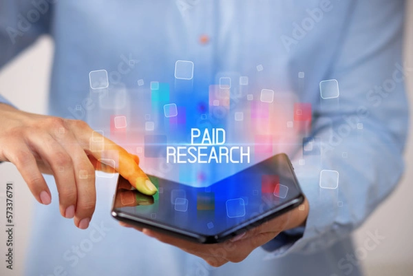 Fototapeta Young man holding a foldable smartphone