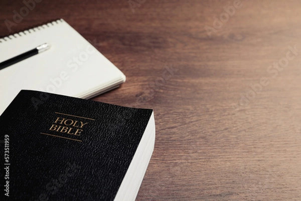 Obraz Holy Bible and notebook with pencil on wooden table, closeup. Space for text. Religious book