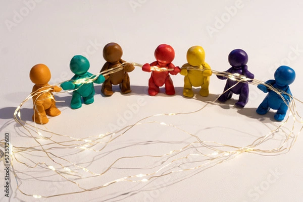 Obraz Figuren aus Knete halten eine Lichterkette, symbolische Darstellung für Zusammenhalt. 
