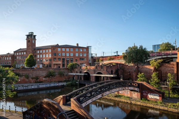 Fototapeta Narrowboat moored on Bridgewater Canal in Deansgate against a blue skyline from Castle field Basin, Manchester, north-west England