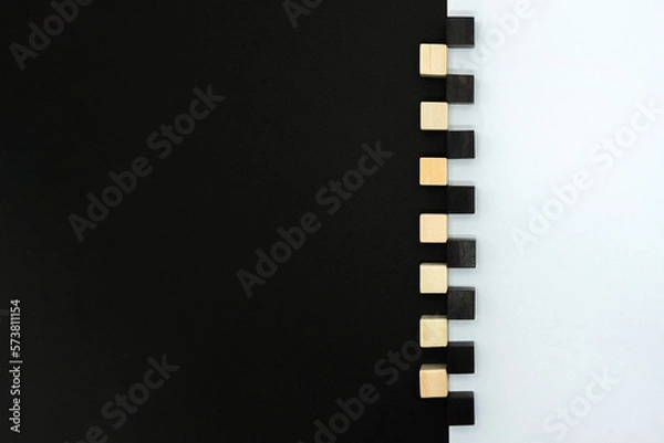 Fototapeta 白と黒のウッドキューブが境目に置かれた黒が多めの背景

