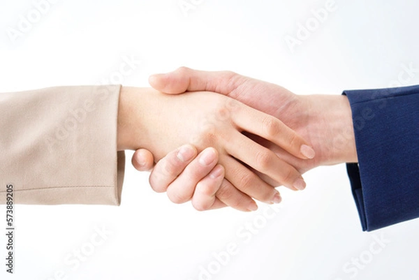 Fototapeta 握手をするビジネスウーマンとビジネスマンの手元のクローズアップ　白背景