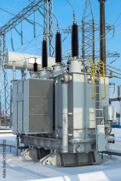 Fototapeta Power transformer in a high-voltage electrical substation outdoors in winter.