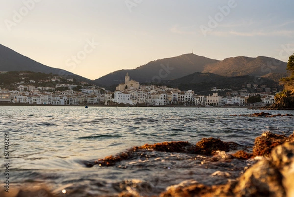 Fototapeta Cadaques, Spain. February 2023. Enjoy a stunning sunset in Cadaques, where the warm tones of the sun blend with the cool hues of the sea, creating a spectacular visual contrast on the coastal horizon.