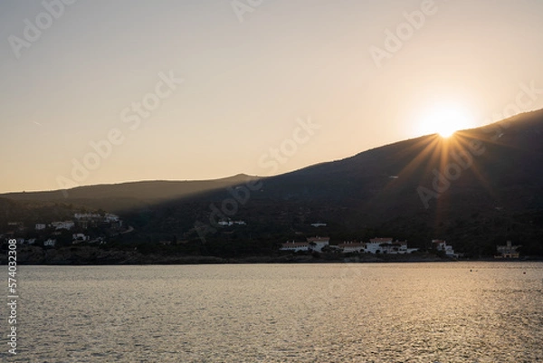 Fototapeta Cadaques, Spain. February 2023. Enjoy a stunning sunset in Cadaques, where the warm tones of the sun blend with the cool hues of the sea, creating a spectacular visual contrast on the coastal horizon.