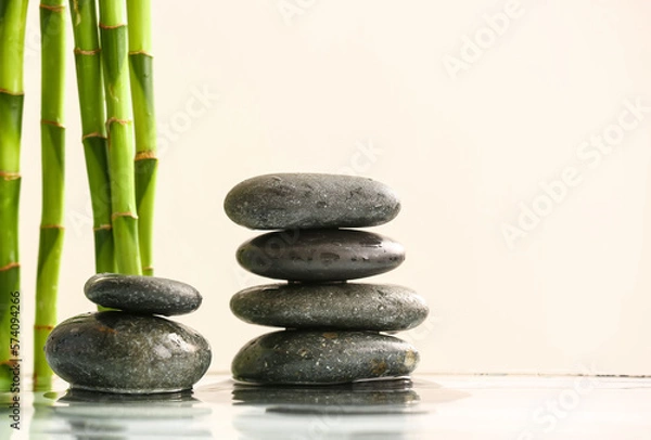Fototapeta Stack of spa stones and bamboo in water on light background