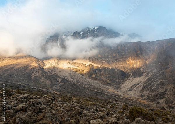 Fototapeta Awe-Inspiring Snowy Mountain Peak Rising Above the Clouds