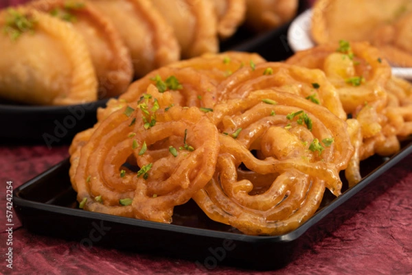 Obraz Jalebi Also Called Jilapi, Jilebi, Jilipi, Zulbia, Jerry, Zalebi, Mushabak Is Indian Mithai Made Of Fermented All Purpose Flour Maida, Besan Fried In Desi Ghee Dunked In Sugar Syrup Cheeni Ki Chasni