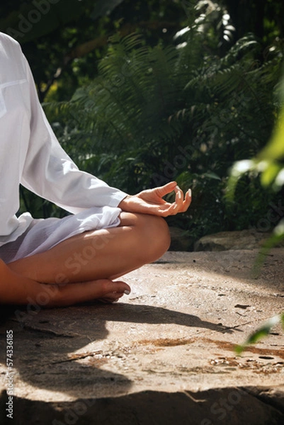 Obraz Fragment like image of young woman practicing yoga in tropic environment
