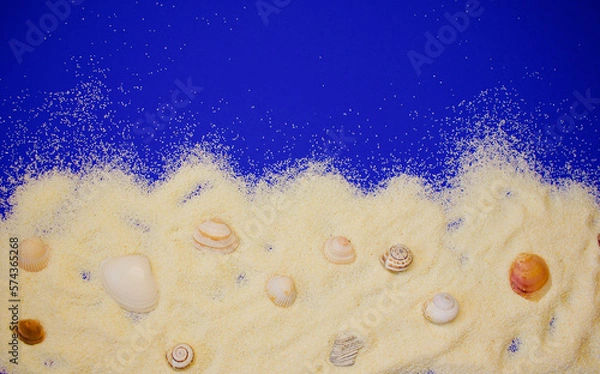 Obraz shells and snail shells on white fine-grained sand on a blue background, close up, copy space