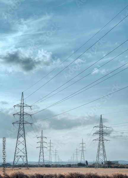 Obraz High voltage electricity towers under the sky. with cinematic look, in vertical 