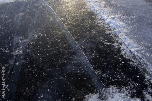 Obraz beautiful cracks in the ice. Volga in winter. Sunset on the winter river