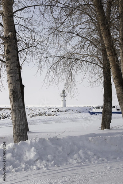 Obraz lighthouse on the coast in winter. Beautiful view on the mountains