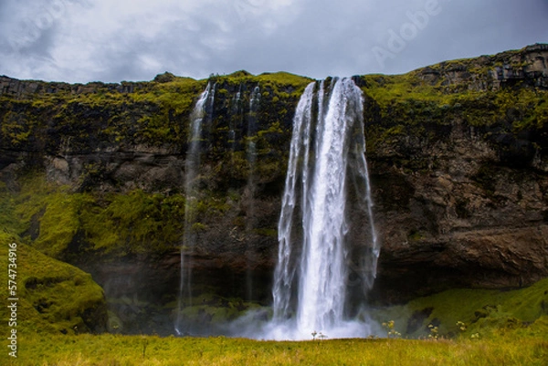 Fototapeta Seljalandsfoss Iceland is a stunning waterfall that allows visitors to walk behind the cascading water.