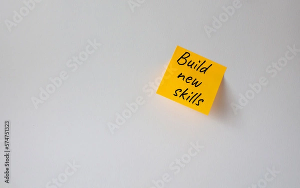Fototapeta Build New skills symbol. Concept word Build New skills on orange steaky note. Beautiful white background. Business and Build New skills concept. Copy space