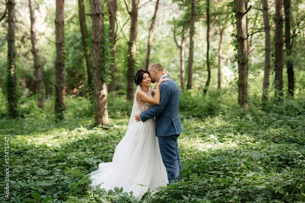 Fototapeta wedding walk of the bride and groom in the deciduous forest in summer