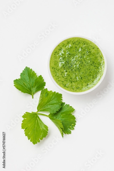 Fototapeta Celery or parsley green sauce in a white ceramic bowl on a white background isolated top view