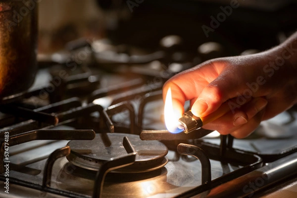 Fototapeta Igniting a gas lighter in a gas stove