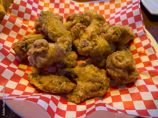 Fototapeta Close up, selective focus on Korean fried chicken in a basket with red checkered paper
