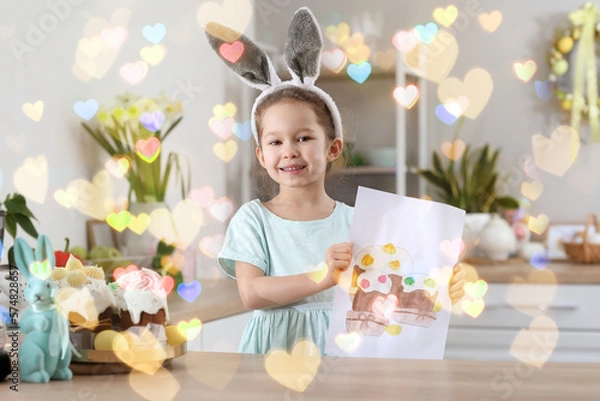Fototapeta Cute little girl with painted Easter cakes on paper sheet in kitchen at home