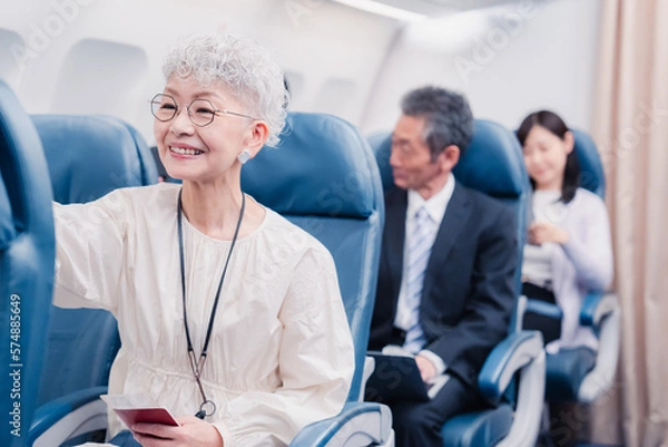 Fototapeta 機内エンターテイメントを楽しむ高齢の女性