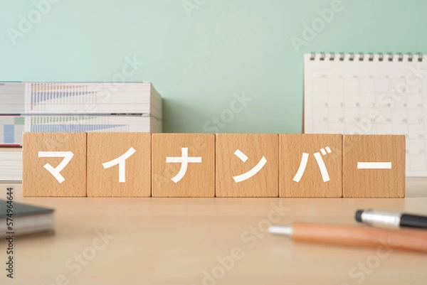 Obraz マイナンバーと書かれたブロックが置かれたデスク
