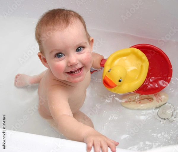 Fototapeta The child bathing in a bath and playing toys