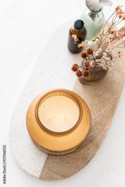Obraz Overhead view of a big twin wick ornamental scented candle over an oval wooden and granite board.