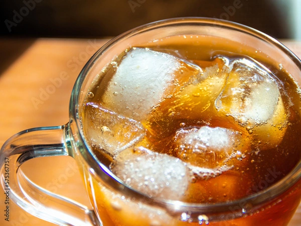 Fototapeta a glass of soda with ice on a wooden table