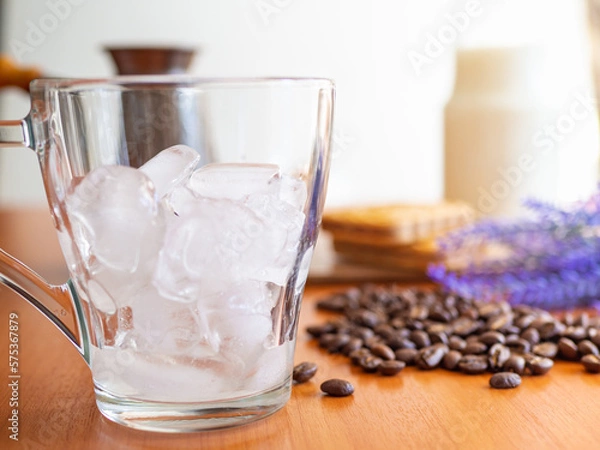 Fototapeta a glass of ice and coffee beans on a table, Cookies and milk bottle on background