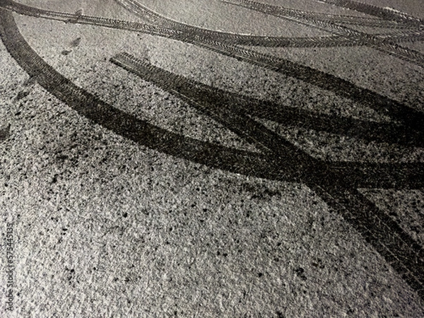Fototapeta Snowy trail: tire imprints on the freshly fallen snow on road