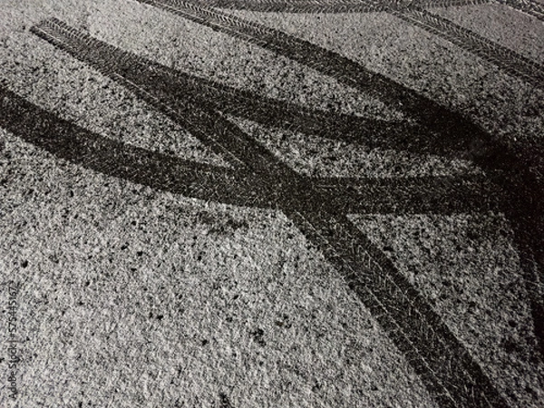 Obraz First snowfall: tire tracks on snowy asphalt road