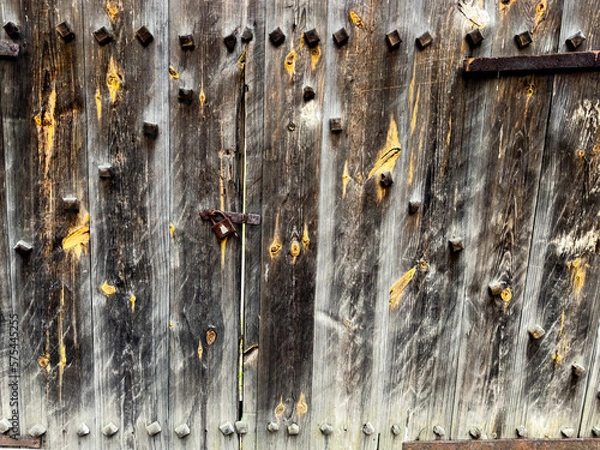 Fototapeta The old wooden door is closed with an old lock